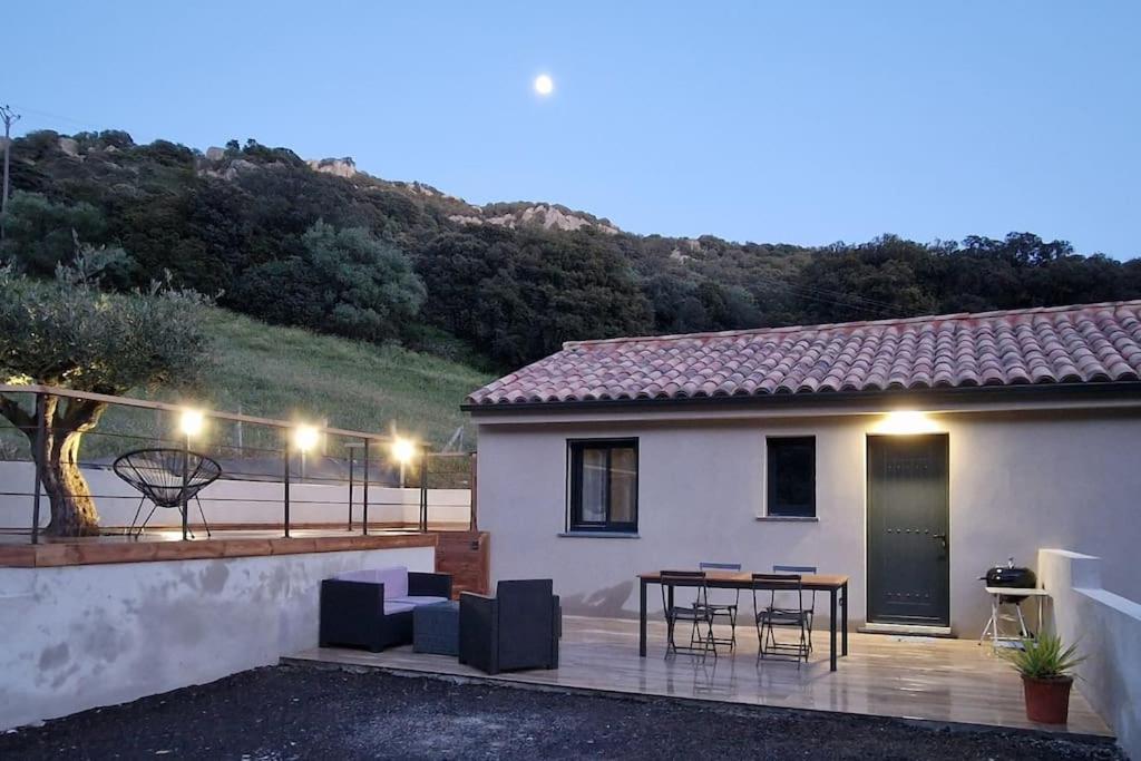 une maison dotée d'une terrasse avec des chaises et une table dans l'établissement Belle villa à la campagne dans un coin cosy, à Sartène