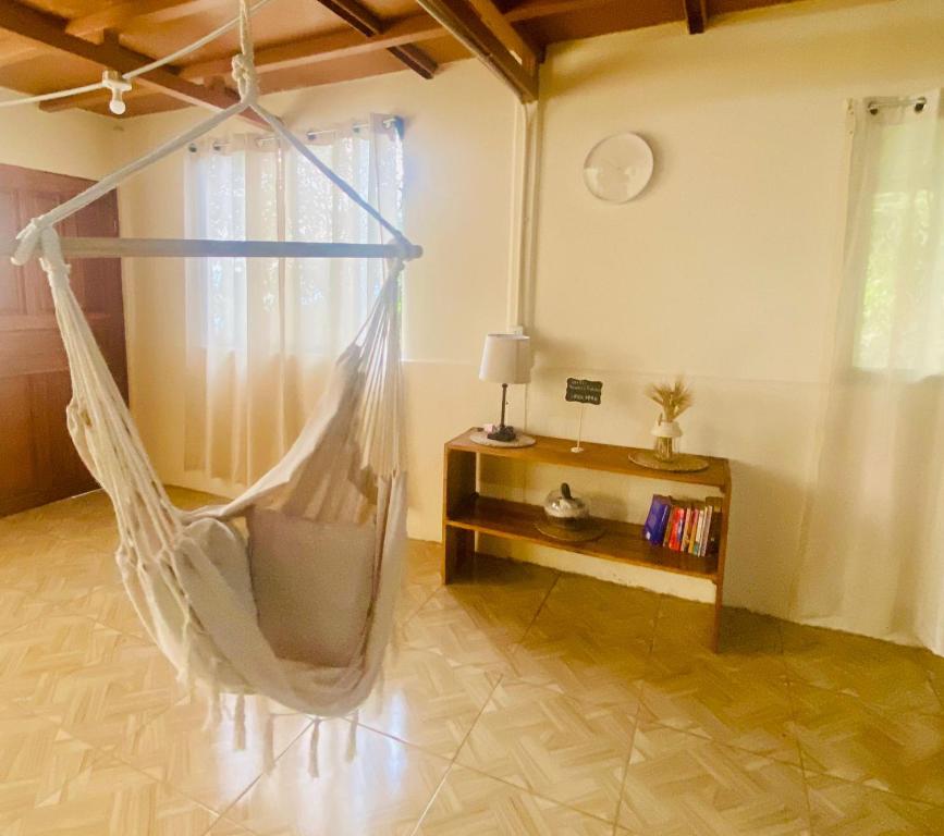 um quarto com uma rede de descanso num quarto em Cabaña Monarca em Turrialba