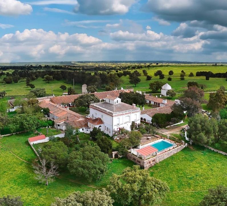 una vista aérea de una casa grande con piscina en Hotel Rural El Vaqueril, en Navas del Madroño