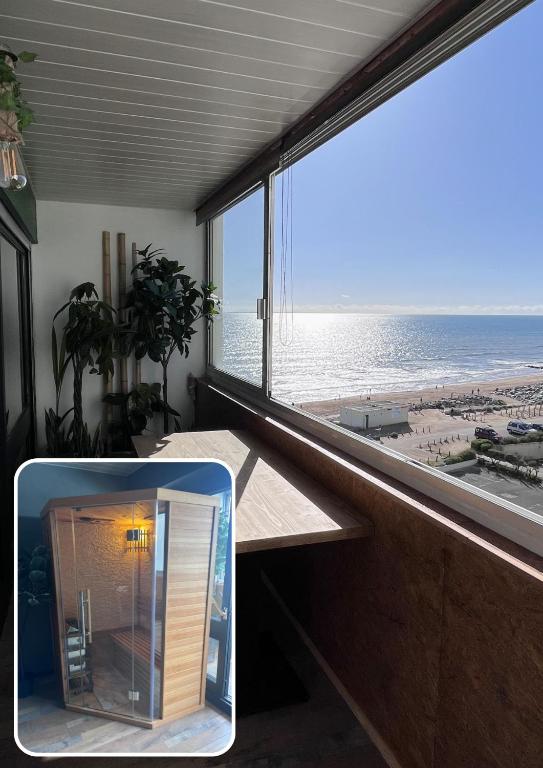 a view of a beach from a room with a window at Oasis Tropical Sauna Privé Vue Mer & Plage À 100M in Saint-Hilaire-de-Riez