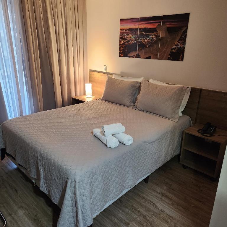 um quarto com uma cama com toalhas em Suíte Premiere no Rio de Janeiro