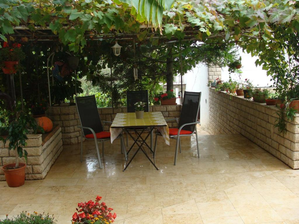 a patio with a table and chairs and plants at Apartment Boris in Labin