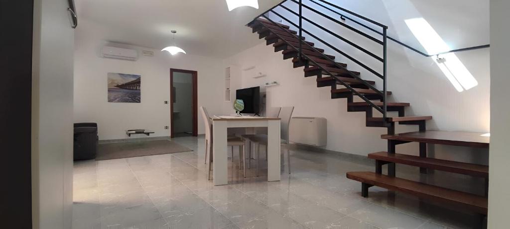 sala de estar con escalera y mesa en Casa Andros, en Pertosa