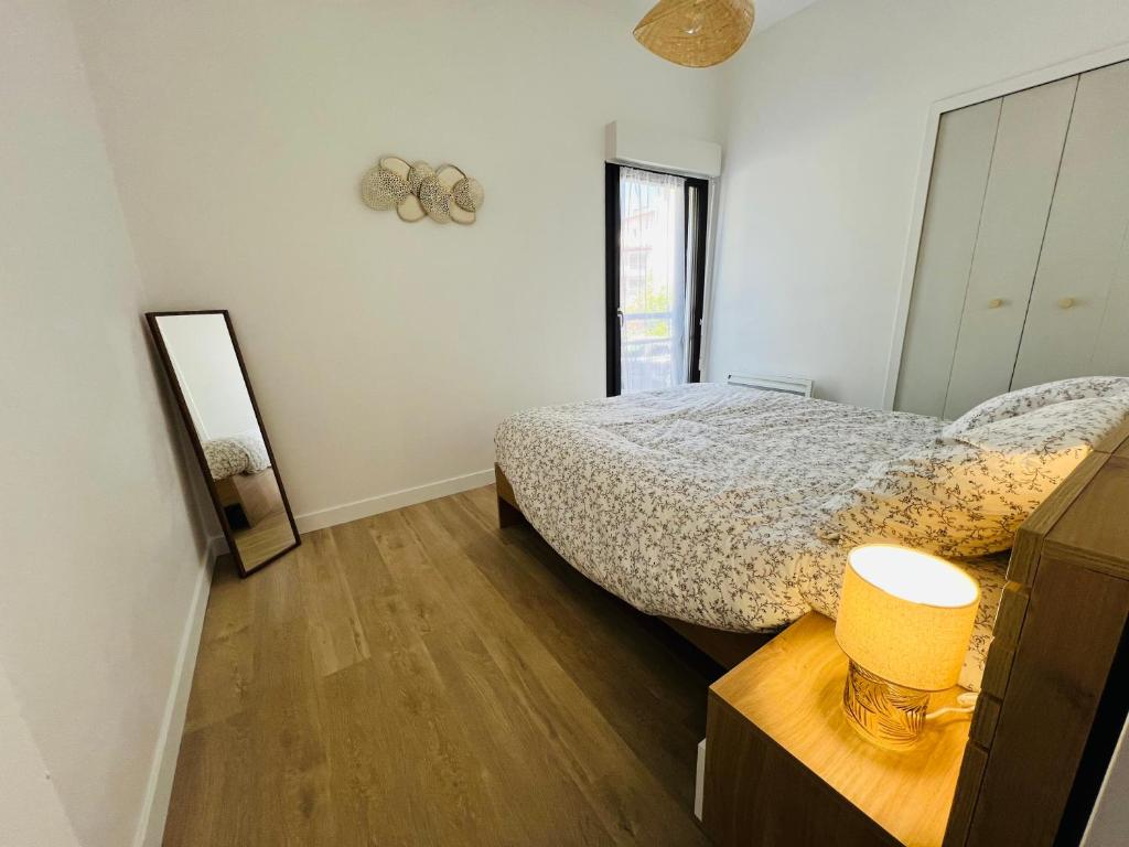 une chambre avec un lit et un miroir dans l'établissement Havre de paix cures thermales, à Dax