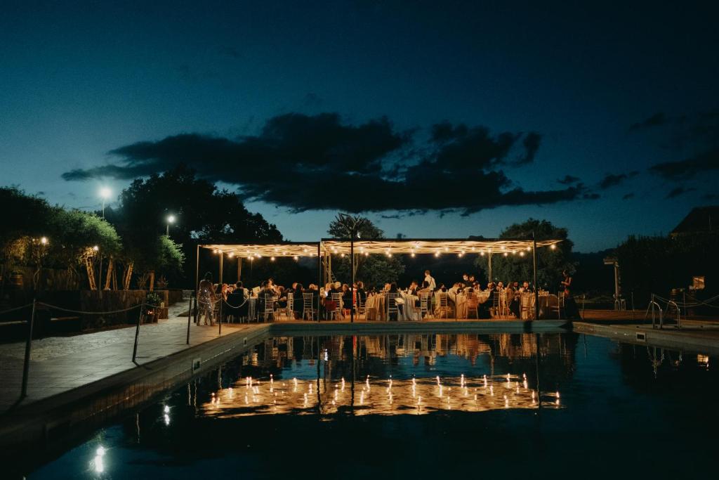 a wedding ceremony in a pool at night with lights at Borgata Baldazza in Linguaglossa