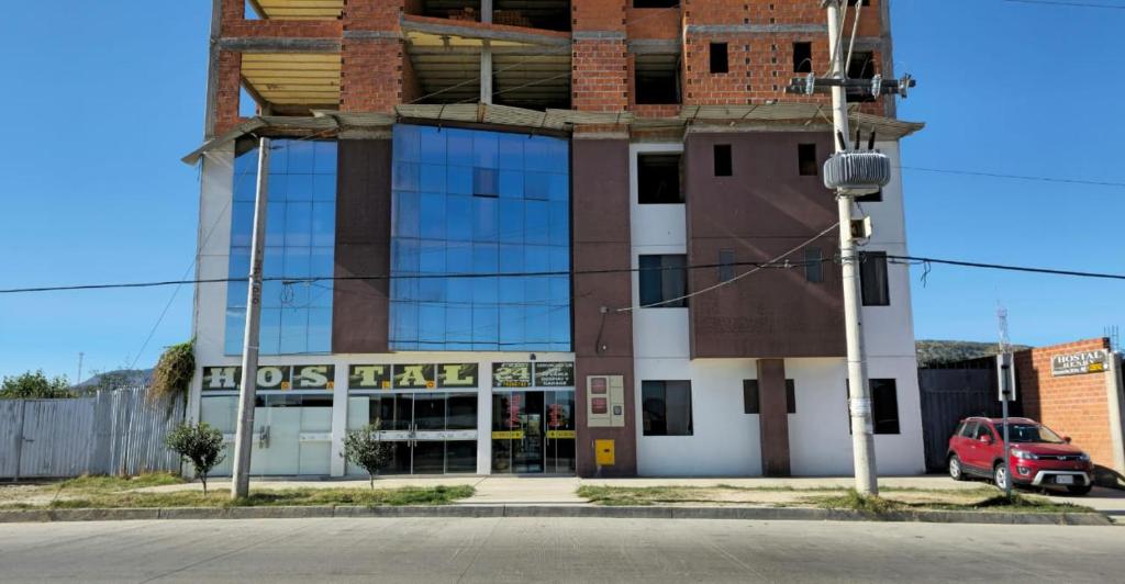 un edificio con un coche aparcado delante de él en HOSTAL GALO, en Tarija