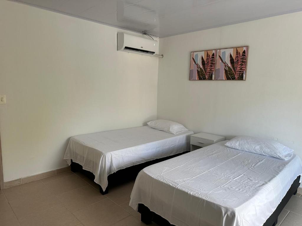 Habitación con 2 camas y una foto en la pared. en Leonor’s Guest House en Providencia