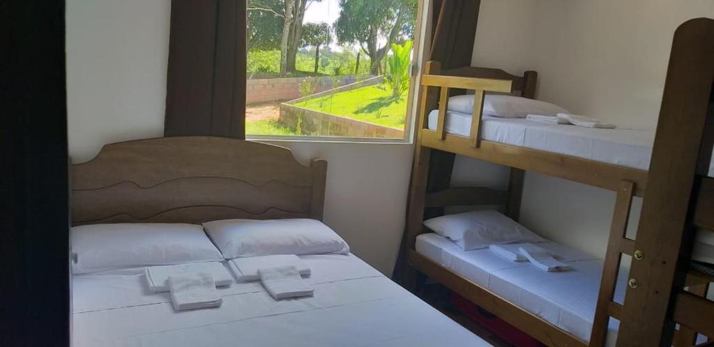 1 Schlafzimmer mit 2 Etagenbetten und einem Fenster in der Unterkunft Pousada Chacara Princesa Isabel in São José da Barra