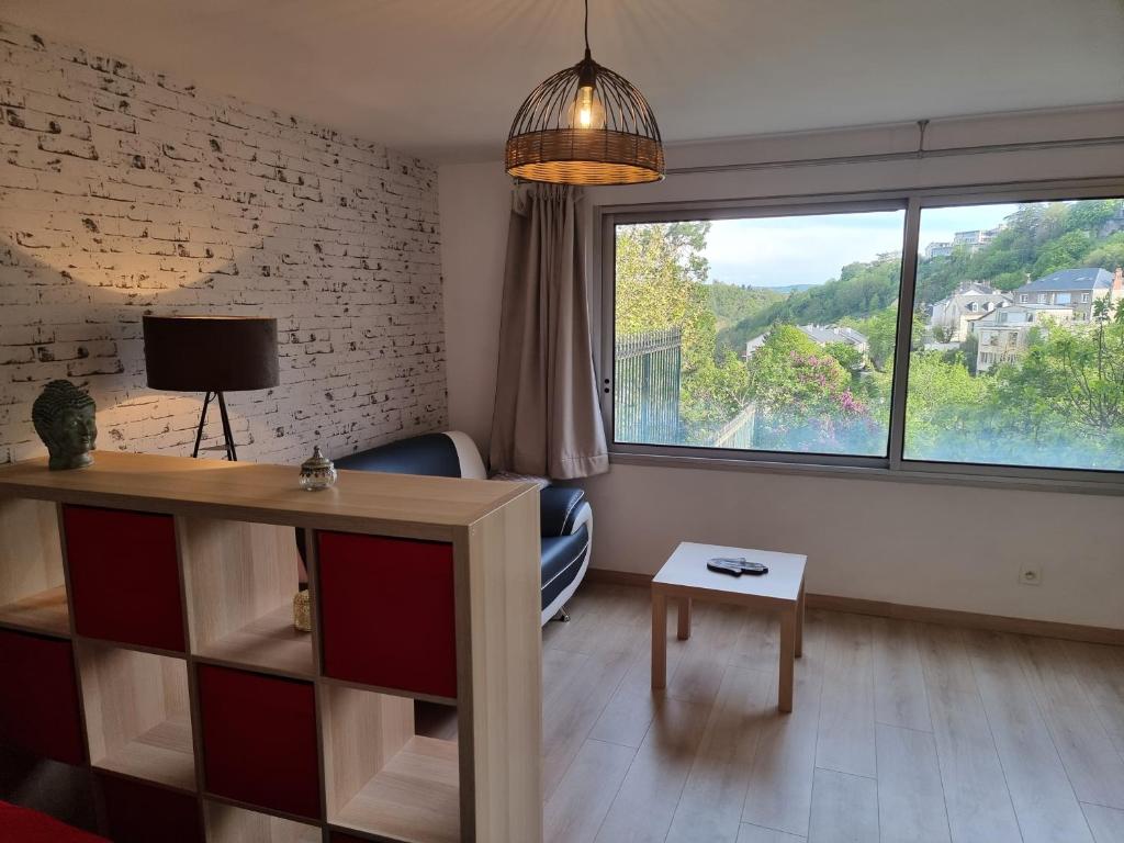 sala de estar con ventana grande y TV en Le Lumineux, en Rodez