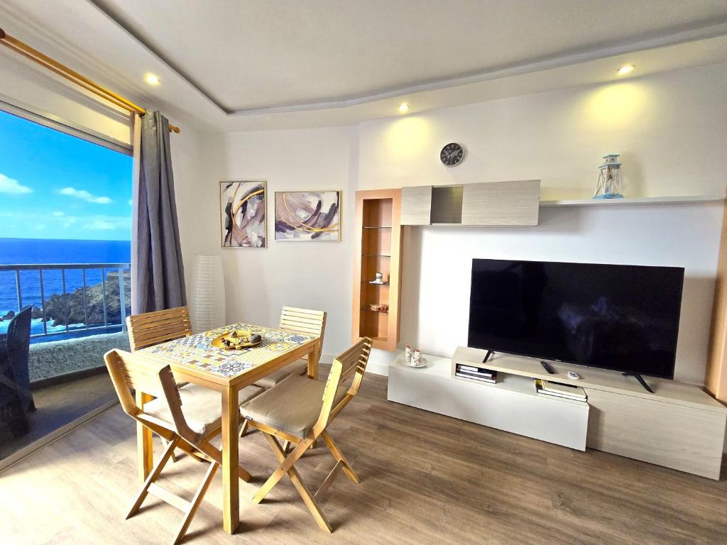 a dining room with a table and a large television at Mirador de Encantos Playa San Marcos in San Marcos
