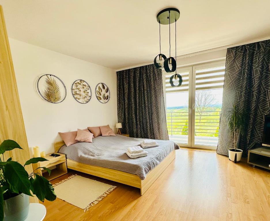 una camera da letto con un letto e una grande finestra di Apartament Sweet Time a Huta Szklana