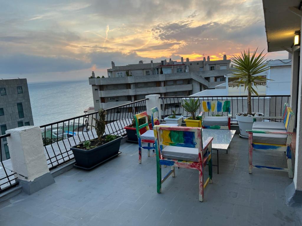 a balcony with chairs and tables and the ocean at Atico A in Salou