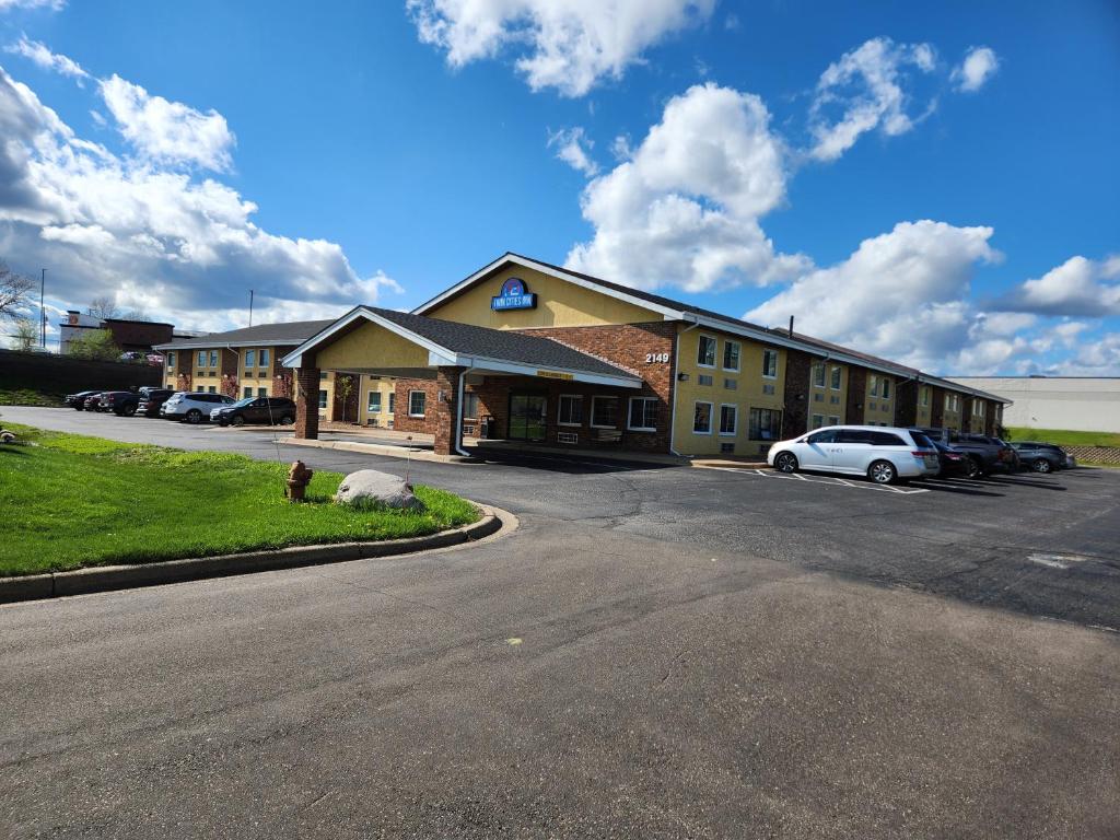 a large building with cars parked in a parking lot at Twin Cities Inn, Mounds View in Mounds View