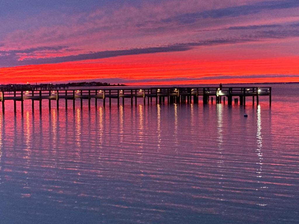 uma doca na água com um pôr-do-sol vermelho em Romantic Island condo for 2 - Sunset Harbor 1-205 - Navarre Beach em Navarre