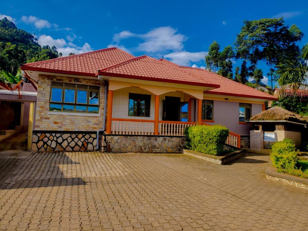 a house with a red roof on a brick driveway at Mianzi Guest House in Kisoro