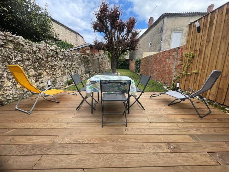una mesa y sillas en un patio en Le jardin de l'Ostal, en Casteljaloux
