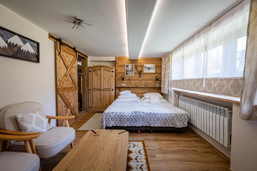 a bedroom with a bed and a table and a chair at Zacisze Pod Reglami & Sauna in Zakopane