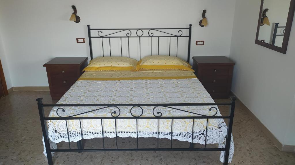 una cama negra con almohadas amarillas en una habitación en Amelia Sweet Home - Farindola, en Farindola