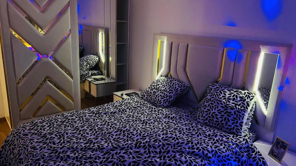 a bedroom with a bed with blue lights on it at Appartement Luxueux de haut standing avec une terrasse vue sur la ville lumière in Lyon