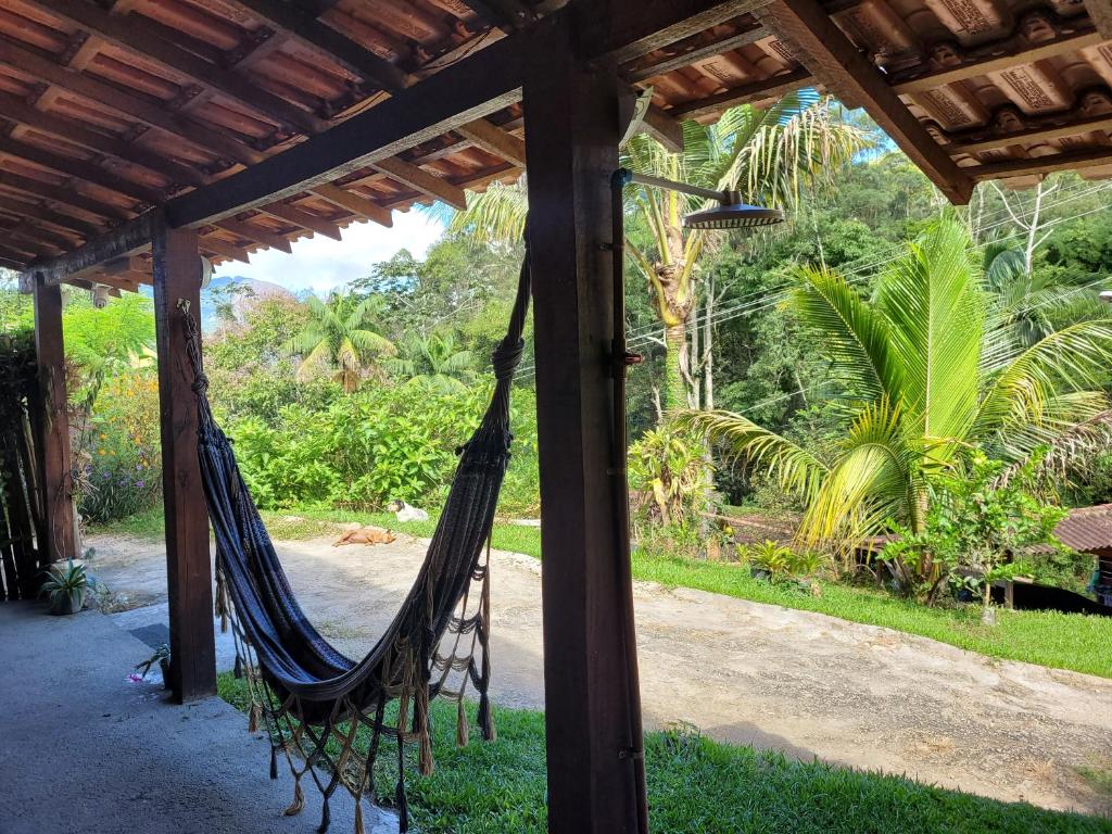 a hammock in a porch with a view of a garden at Casa girassol in Nova Friburgo