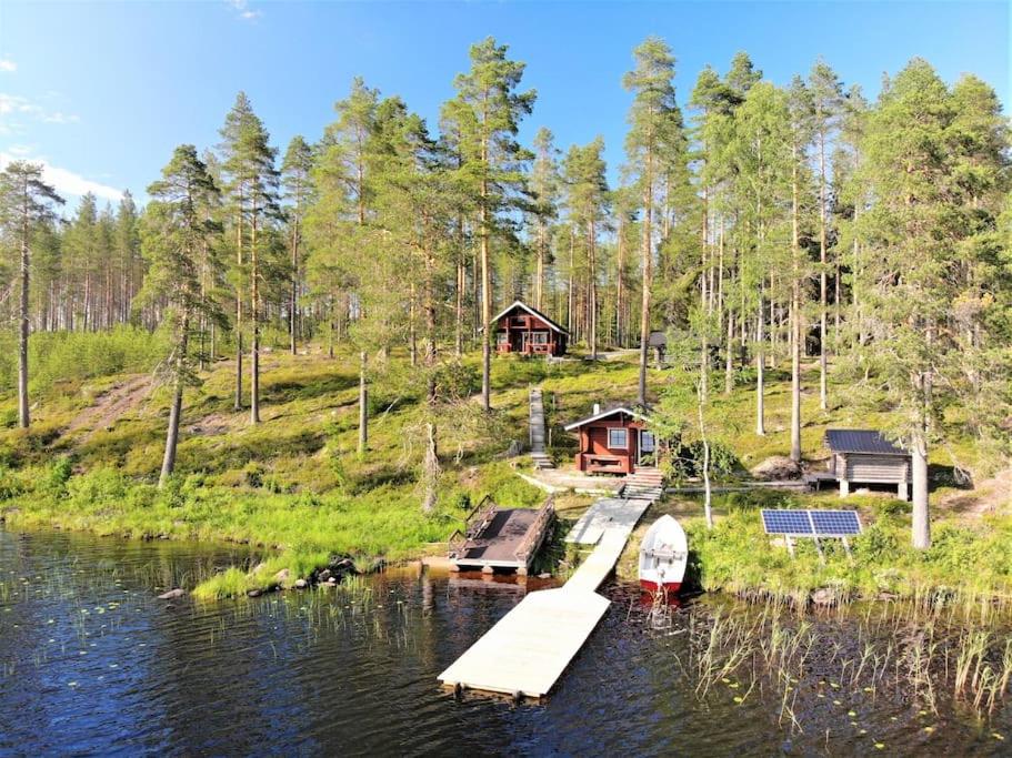 a house on a hill next to a body of water at Lomamökki Kuhmo, Tervatörmä in Kuhmo