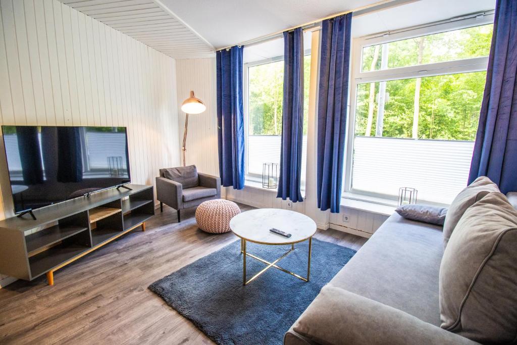 - un salon avec un canapé et une télévision dans l'établissement Schöne Wohnung für 4 Gäste an der Eilenriede mit kostenlosen Parkplätzen, à Hanovre