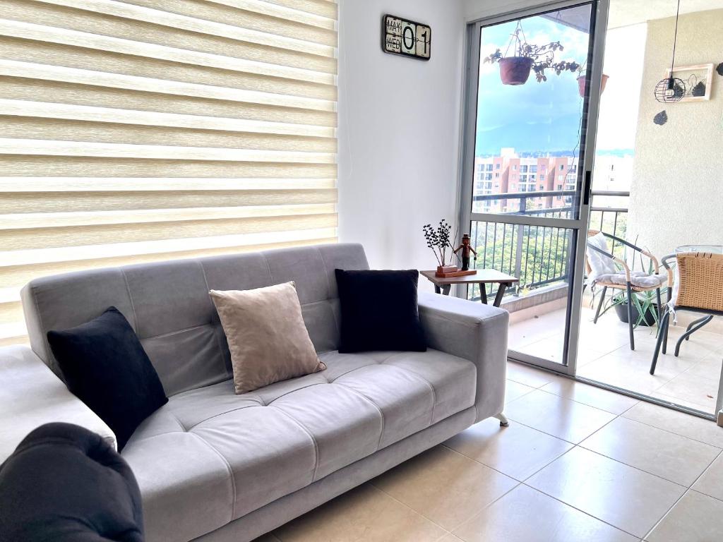 a living room with a couch and a balcony at Cómodo Apartamento en el sur de Cali in Cali