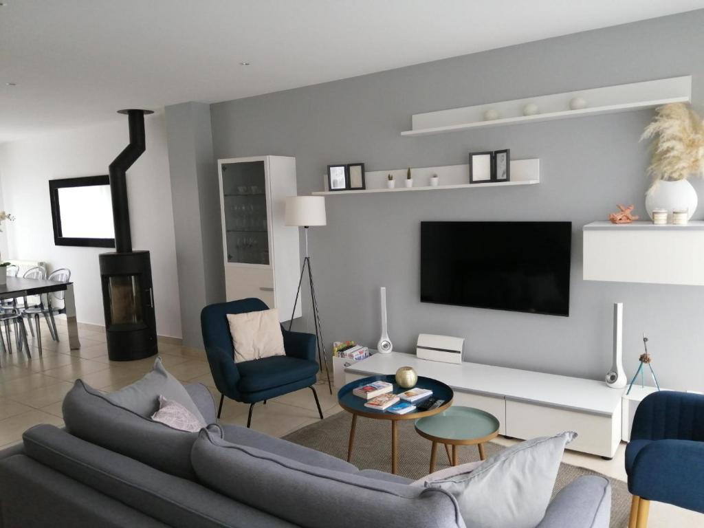 uma sala de estar com um sofá e uma televisão em Maison proche Disneyland em Champs-Sur-Marne