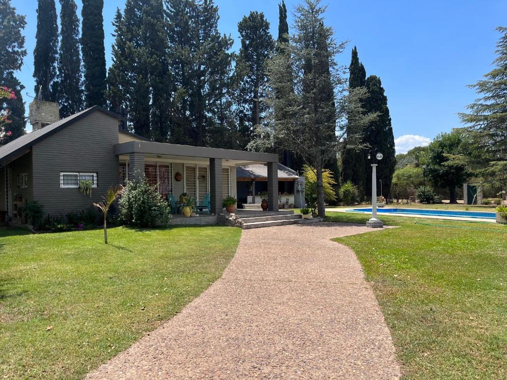 a house with a pathway in front of a yard at Casa de fin de semana El Ancla in Campos Salles