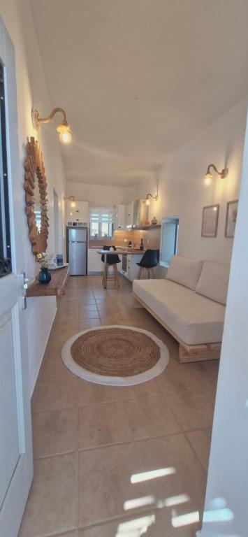 a living room with a white couch and a kitchen at Aloni in Áno Meriá