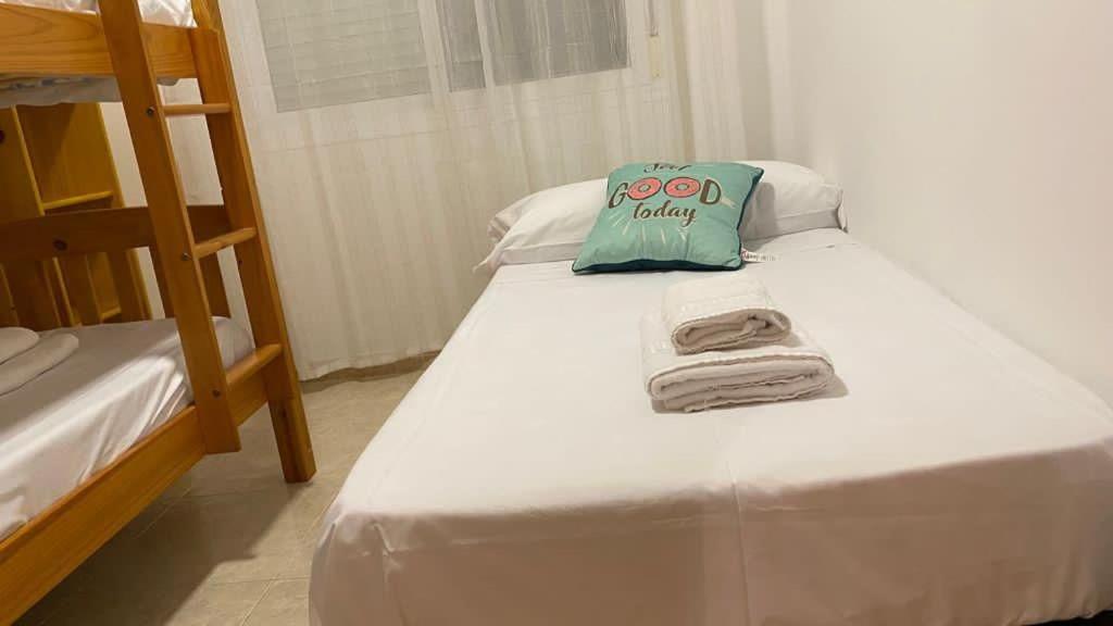 - un lit avec un oreiller et des serviettes dans l'établissement Apartament Els Flamencs, à Els Muntells