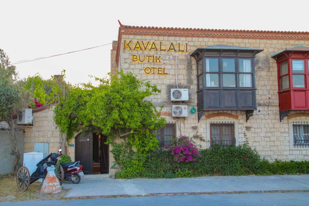 un edificio con una moto aparcada delante de él en Alaçatı Kavalalı Otel, en Alacati