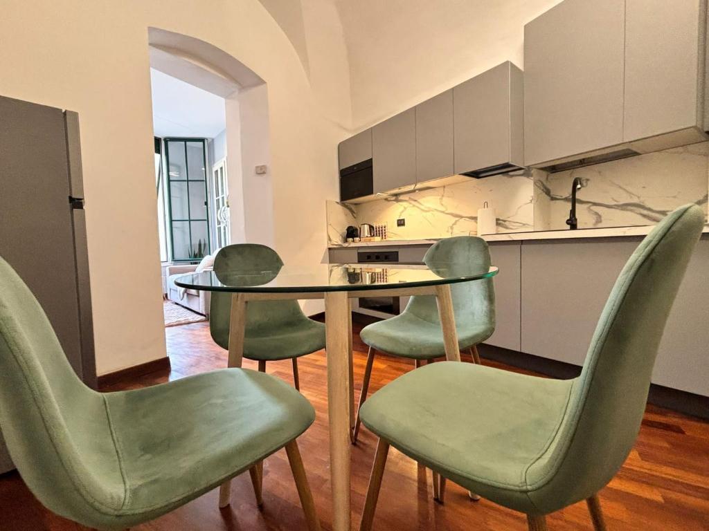 una cucina con tavolo e 4 sedie verdi di Casa Jolie - vista castello a Dolceacqua