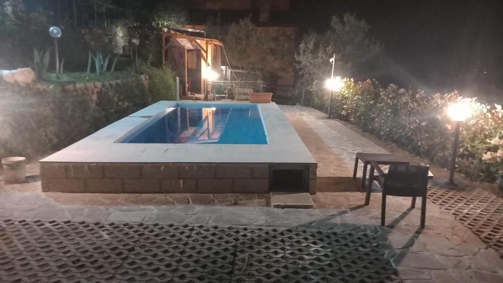 a swimming pool at night with a table and lights at Il Podere di Massi in Barberino di Mugello