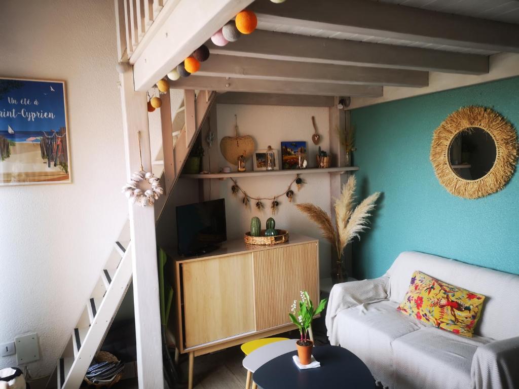 un salon avec un canapé et un escalier dans l'établissement T2 résidence piscine et direct plage, à Saint-Cyprien