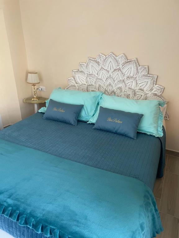 - un lit avec 2 oreillers bleus au-dessus dans l'établissement DiVi Palace, à Torre Annunziata