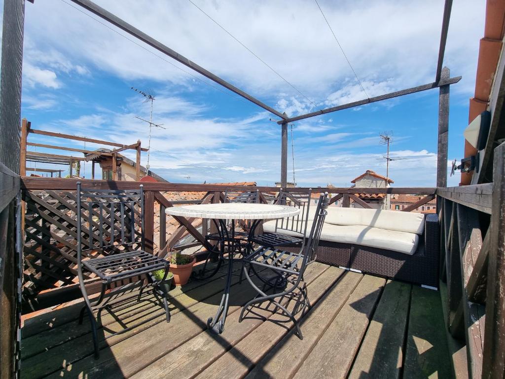 een terras met een tafel en stoelen op een dek bij BIENNALE TERRACE in Venetië