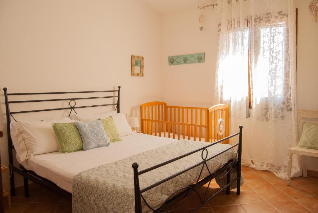 een slaapkamer met een bed en een raam bij Villa Angedras in San Teodoro