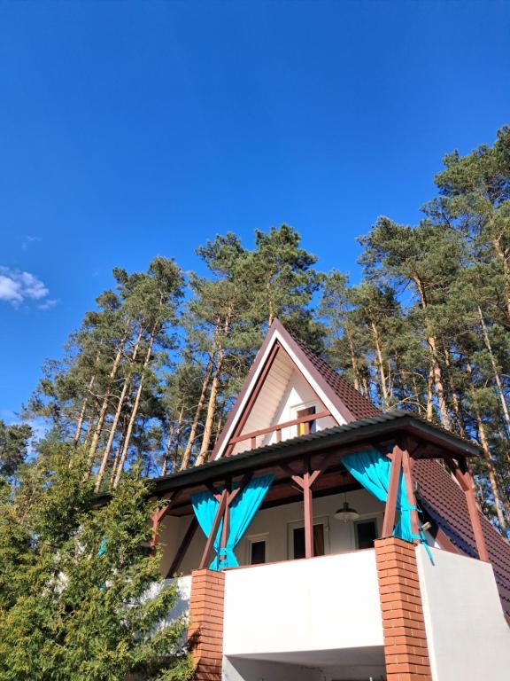 a house with a roof with trees in the background at Ostoja Lipiny 