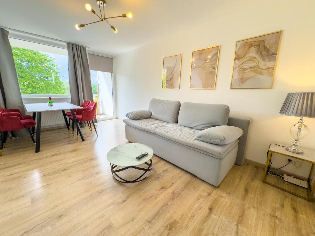 a living room with a couch and a table at Messe-Apartment für 5 Gäste mit Balkon und Lift in Hannover