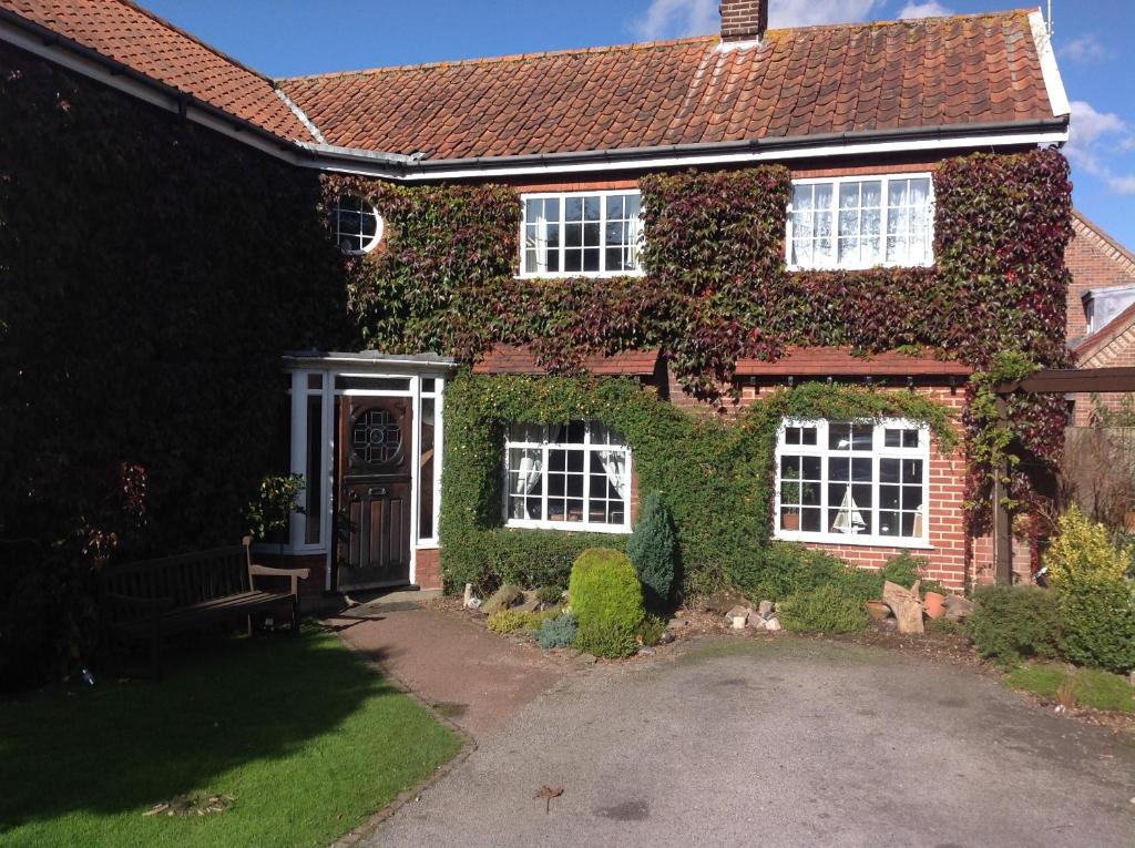 a red brick house with ivy growing on it at The Summer Room in Norwich