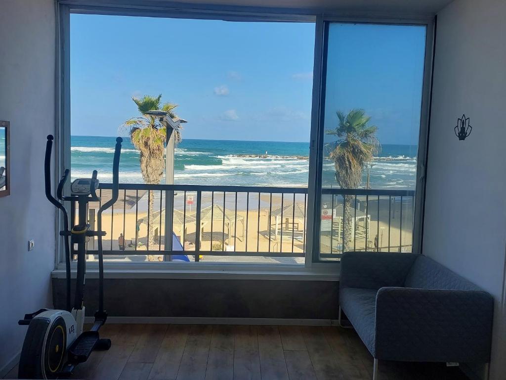 a living room with a view of the beach from a window at Aparthotel Banana Beach in Tel Aviv