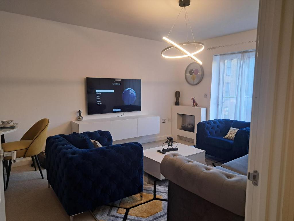 ein Wohnzimmer mit einem Sofa und einem TV in der Unterkunft Stunning Station Apartment in Kent