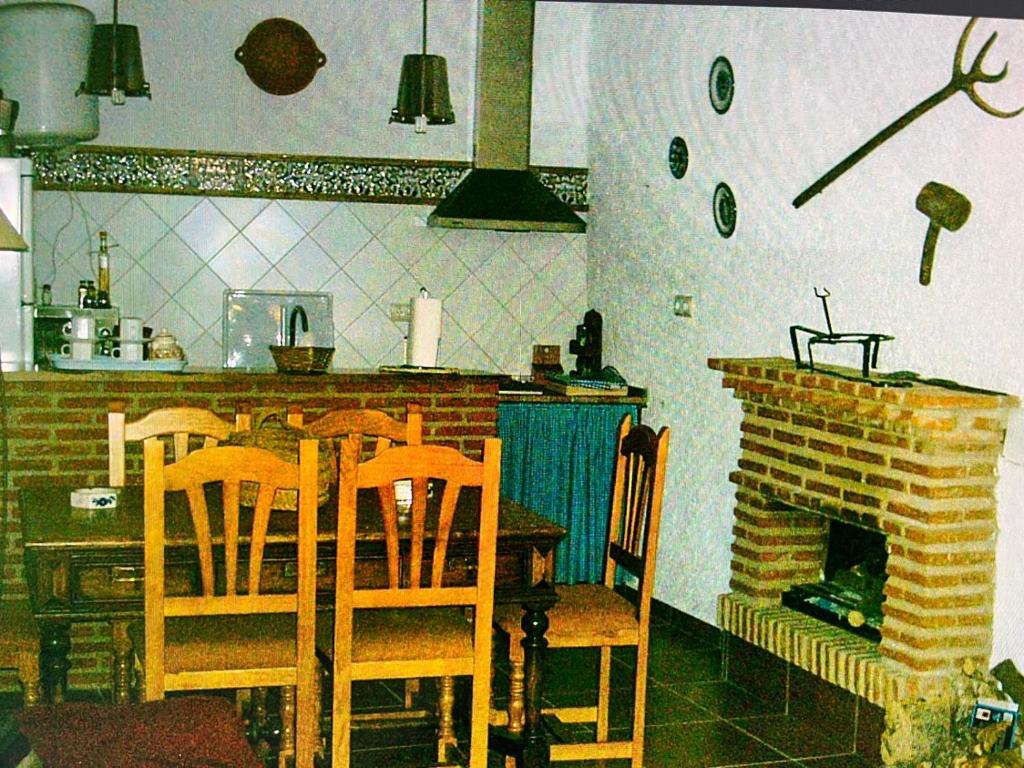 a kitchen with a table and chairs and a fireplace at Casa Adrián in Quesada