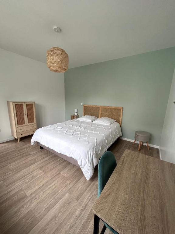 a bedroom with a large bed and a table at La petite maison in Brienon-sur-Armançon
