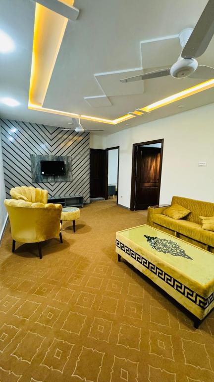 uma sala de estar com duas camas e um sofá em Rahat villas apartment em Islamabad