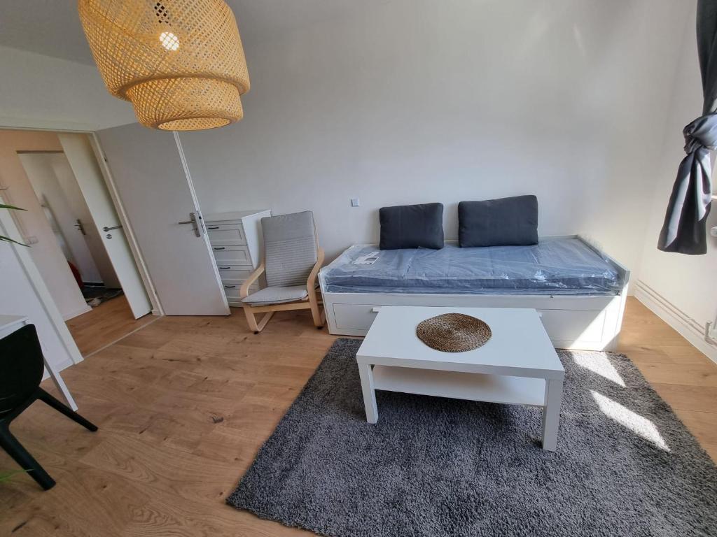 uma sala de estar com uma cama e uma mesa em Beste Apartments em Meerane