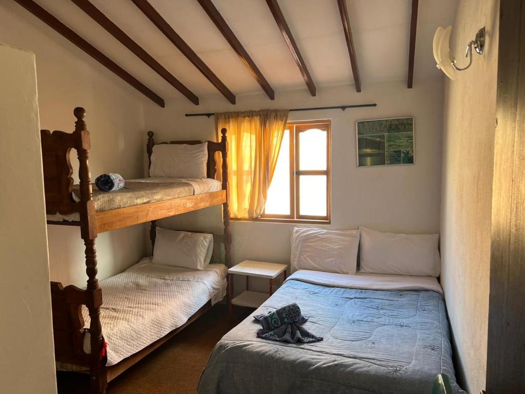 a bedroom with two bunk beds and a window at Casa del Viajero in Villa de Leyva