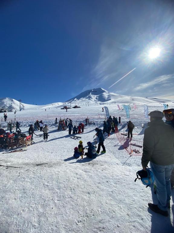 un grupo de personas en una pista de esquí cubierta de nieve en Cabaña en Malalcahuello, en Malalcahuello