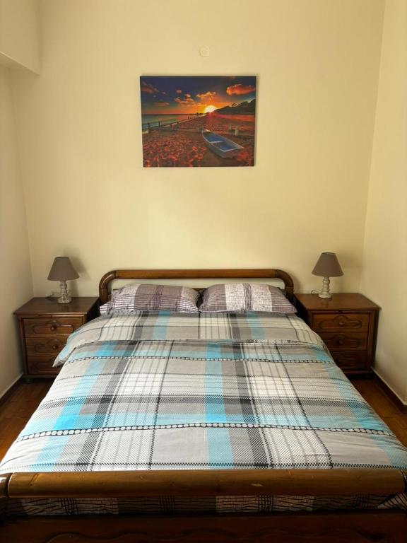 un letto con piumone a quadri in una camera da letto di Комната с общей баней karolou 10 ad Atene